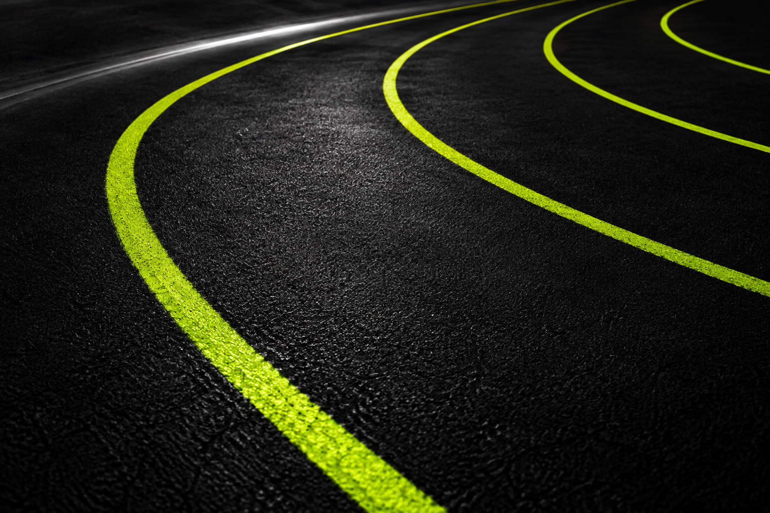 Electric-lime lanes curve across a dark running track.